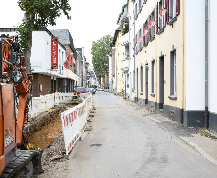 Dörflicher Straßenzug mit Kanalarbeiten auf der linken Seite.